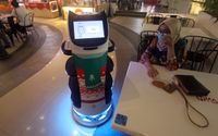 Robot pramusaji berhias nuansa natal siap melayani pengunjung yang memesan makanan. Foto : Panji Asmoro/TrenAsia