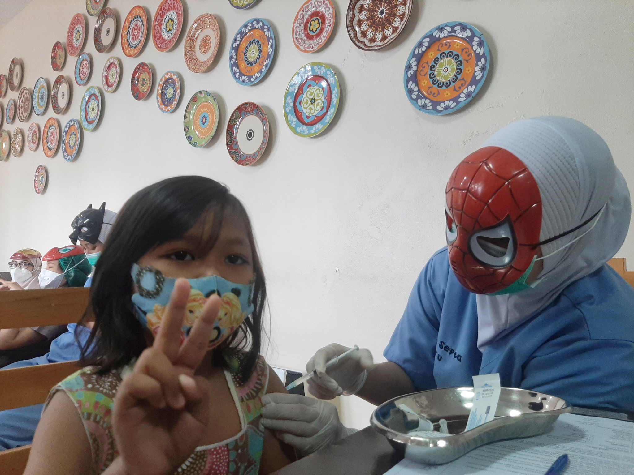 Petugas kesehatan menggunakan topeng karakter superhero saat memberikan vaksin pada anak usia 6-11 tahun di RSIA Tambak, Jakarta, Rabu, 22 Desember 2021. Foto: Ismail Pohan/TrenAsia
