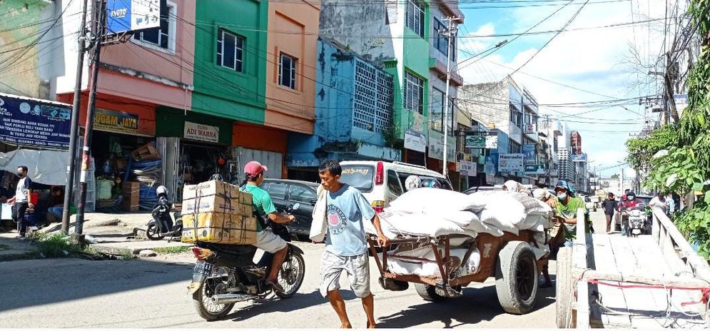 Sejumlah buruh mengangkut gula dengan menggunakan gerobak untuk dikirim ke toko pengecer gula di kawasan Pasar 16 Ilir Palembang