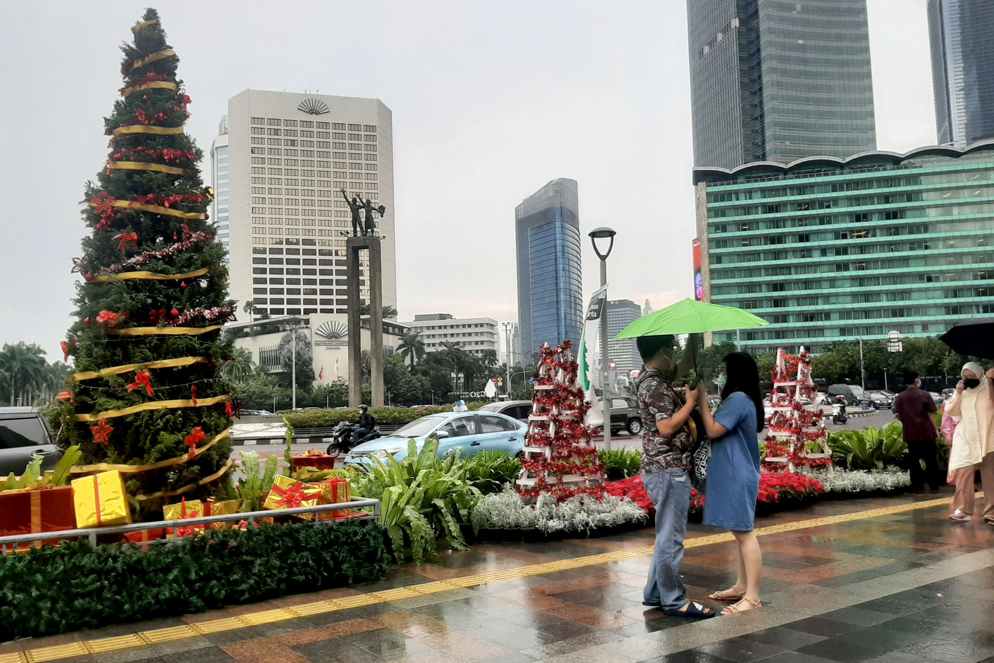 Warga berfoto dengan latar ornamen pohon Natal yang dipajang di pedestrian Bundaran HI, Jakarta, Sabtu, 25 Desember 2021. Foto: Ismail Pohan/TrenAsia