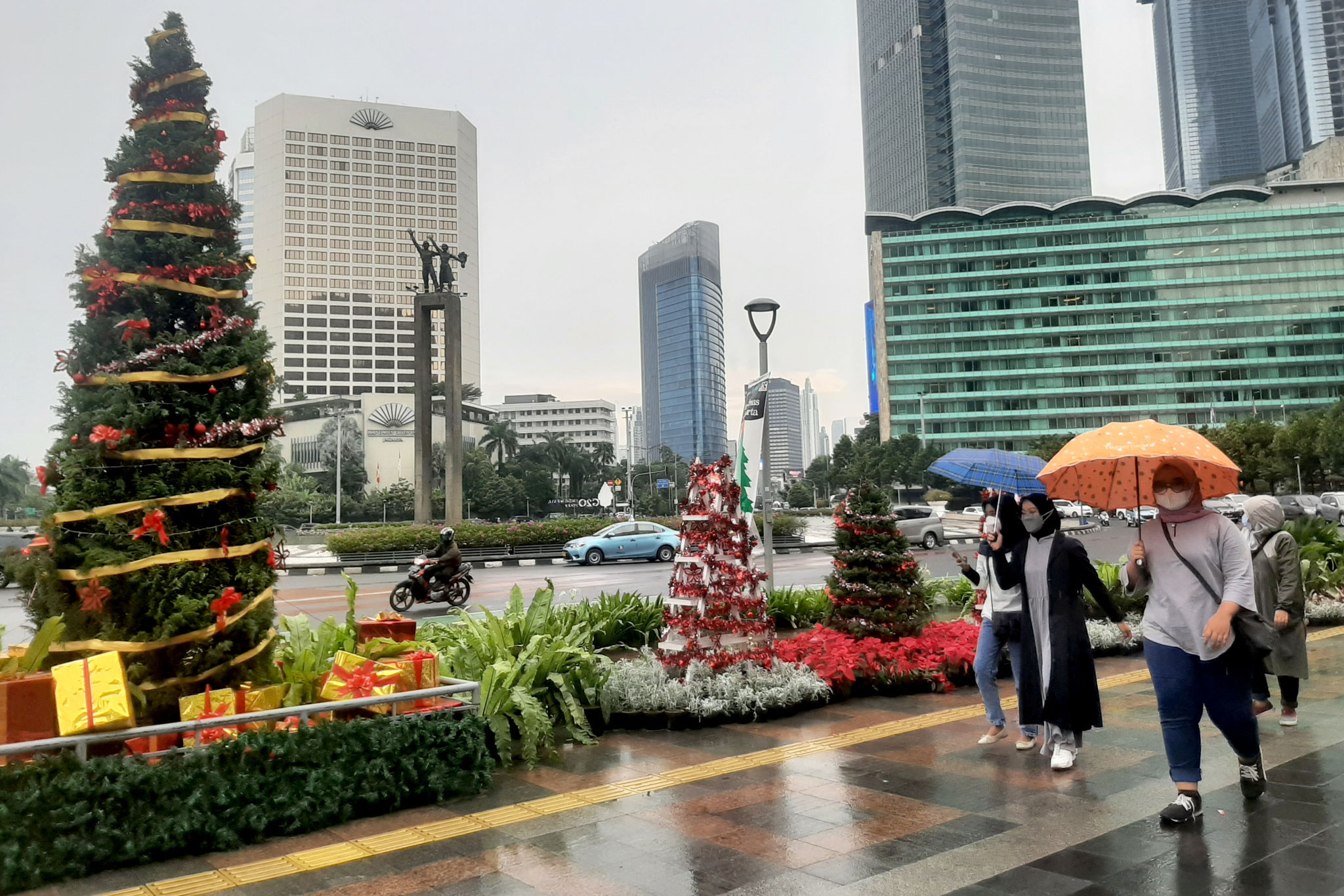 Warga melintas di dekat ornamen pohon Natal yang dipajang di pedestrian Bundaran HI, Jakarta, Sabtu, 25 Desember 2021. Foto: Ismail Pohan/TrenAsia