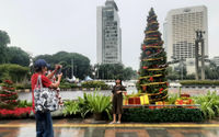 Warga berfoto dengan latar ornamen pohon Natal yang dipajang di pedestrian Bundaran HI, Jakarta, Sabtu, 25 Desember 2021. Foto: Ismail Pohan/TrenAsia