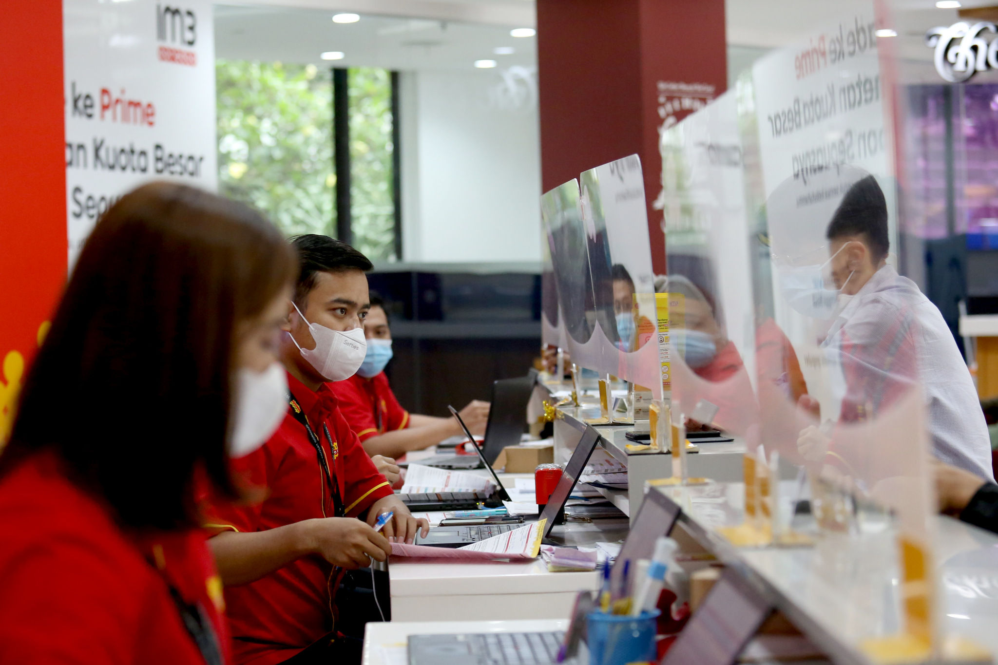 Karyawan melayani pelanggan di gerai Indosat Ooredoo, Jakarta, Rabu, 29 Desember 2021. Foto: Ismail Pohan/TrenAsia