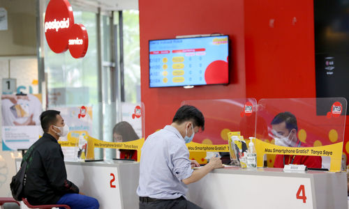 Karyawan melayani pelanggan di gerai Indosat Ooredoo, Jakarta, Rabu, 29 Desember 2021. Foto: Ismail Pohan/TrenAsia