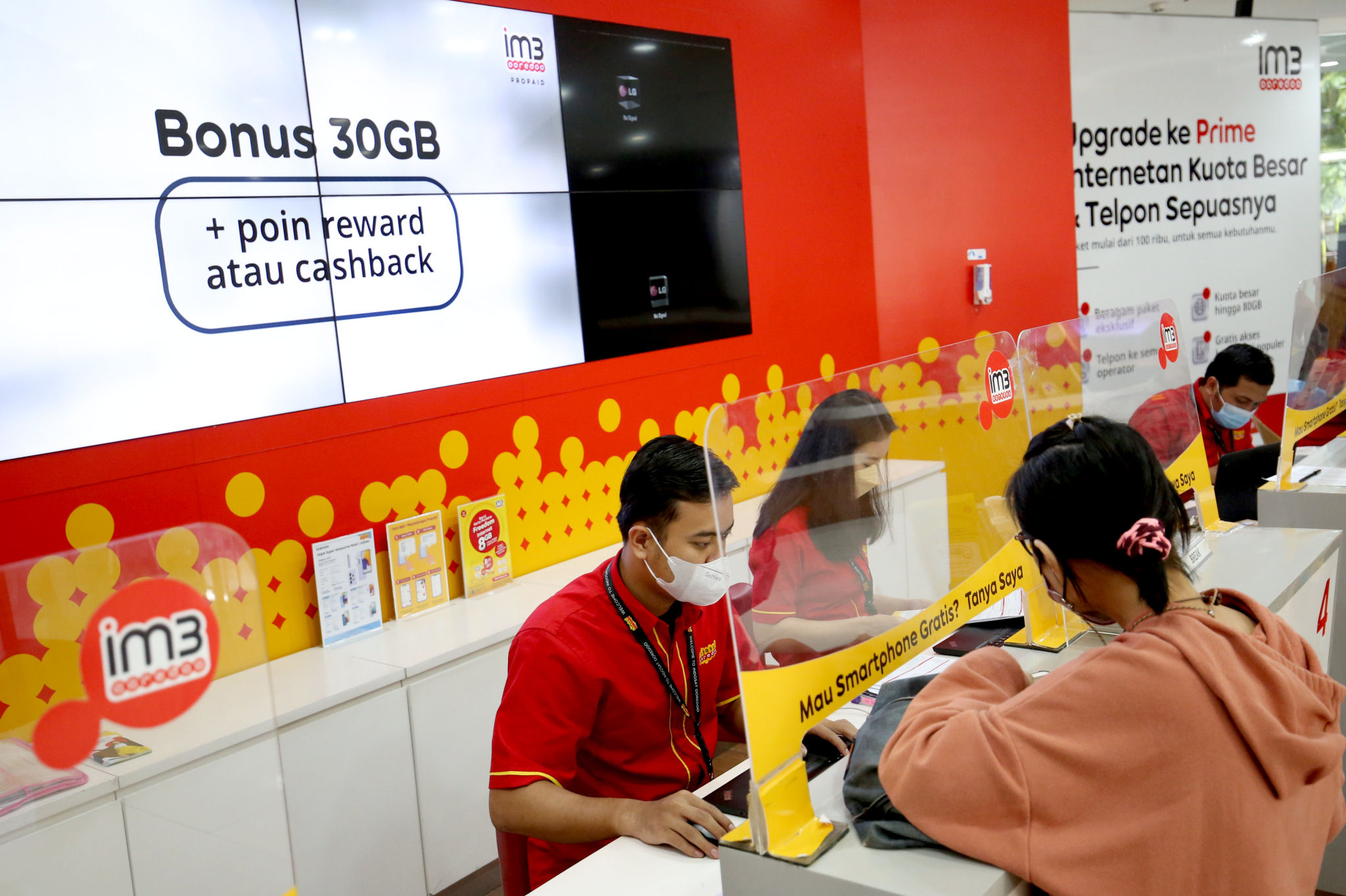 Karyawan melayani pelanggan di gerai Indosat Ooredoo, Jakarta, Rabu, 29 Desember 2021. Foto: Ismail Pohan/TrenAsia