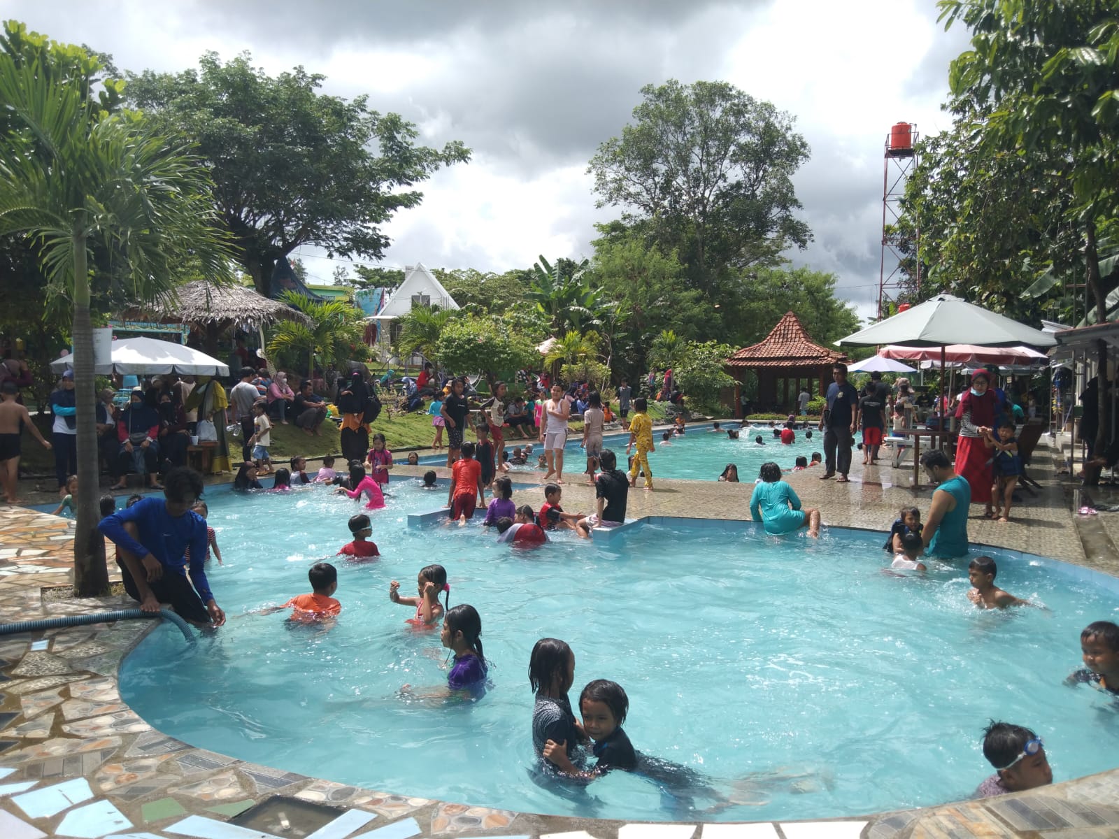Kolam renang di Taman Edum Park ramai dikunjungi wisatawan lokal.