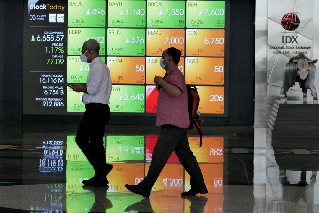 Karyawan beraktifitas dengan latar layar pergerakan indeks harga saham gabungan (IHSG) pada perdagangan perdana di gedung Bursa Efek Indonesia (BEI), Jakarta, Senin, 3 Januari 2022. Foto: Ismail Pohan/TrenAsia