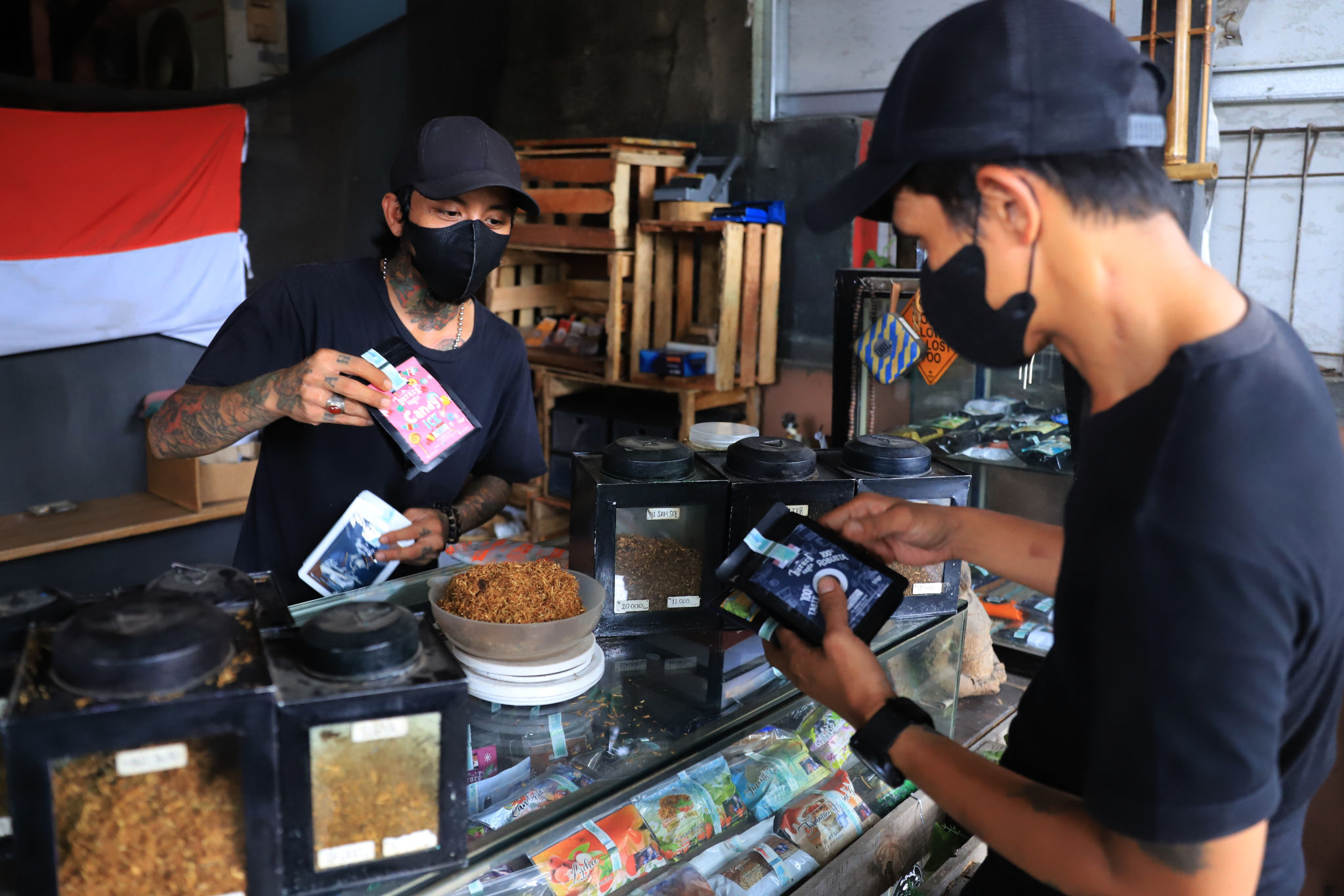 Pekerja melayani konsumen di gerai Kamarasa yang menjual tembakau dengan berbagai varian di kawasan Pondok Cabe, Pamulang, Tangerang Selatan, Rabu, 5 Januari 2022. Foto: Ismail Pohan/TrenAsia