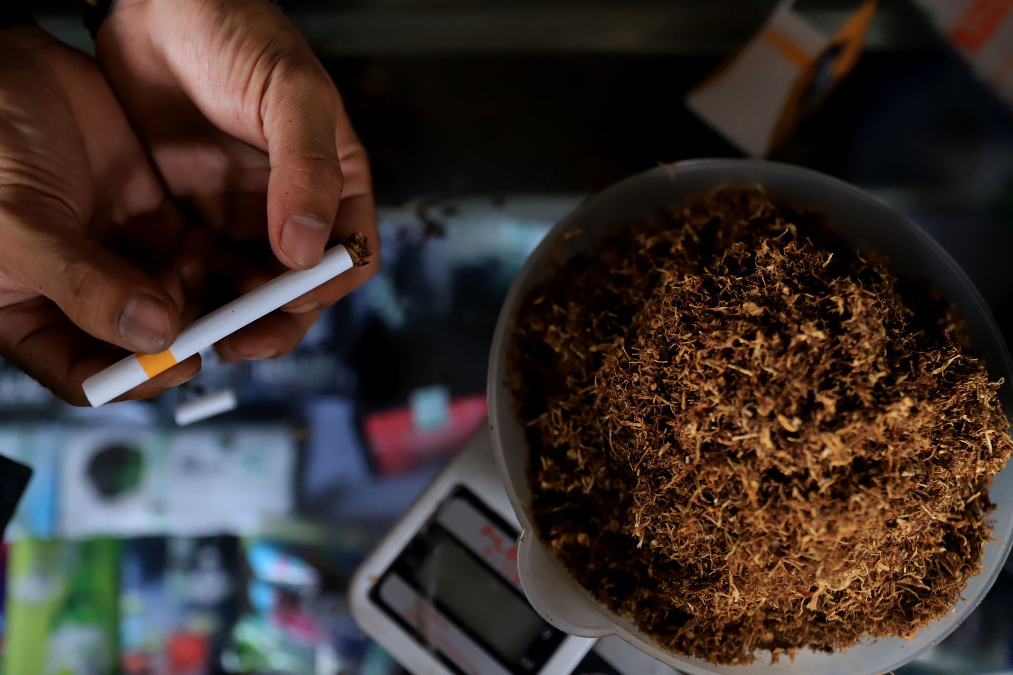 Pekerja melinting tembakau di gerai Kamarasa yang menjual tembakau dengan berbagai varian di kawasan Pondok Cabe, Pamulang, Tangerang Selatan, Rabu, 5 Januari 2022. Foto: Ismail Pohan/TrenAsia