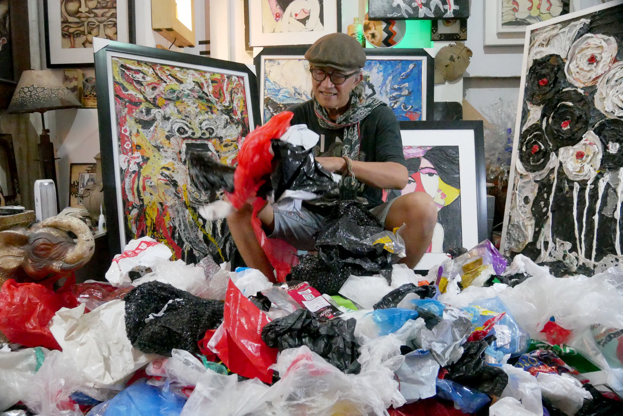 Dwiyono (66) memilah sampah plastik yang akan dijadikan lukisan di workshop galery miliknya di kawasan Rawamangun, Jakarta Timur, Kamis, 6 Januari 2022. Foto: Ismail Pohan/TrenAsia