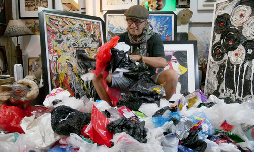 Dwiyono (66) memilah sampah plastik yang akan dijadikan lukisan di workshop galery miliknya di kawasan Rawamangun, Jakarta Timur, Kamis, 6 Januari 2022. Foto: Ismail Pohan/TrenAsia