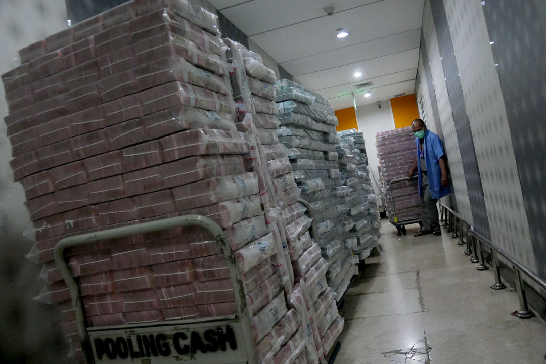 Karyawan memindahkan tumpukan uang rupiah di cash pooling Bank Mandiri, Jakarta, Jum'at, 21 Januari 2022. Foto: Ismail Pohan/TrenAsia