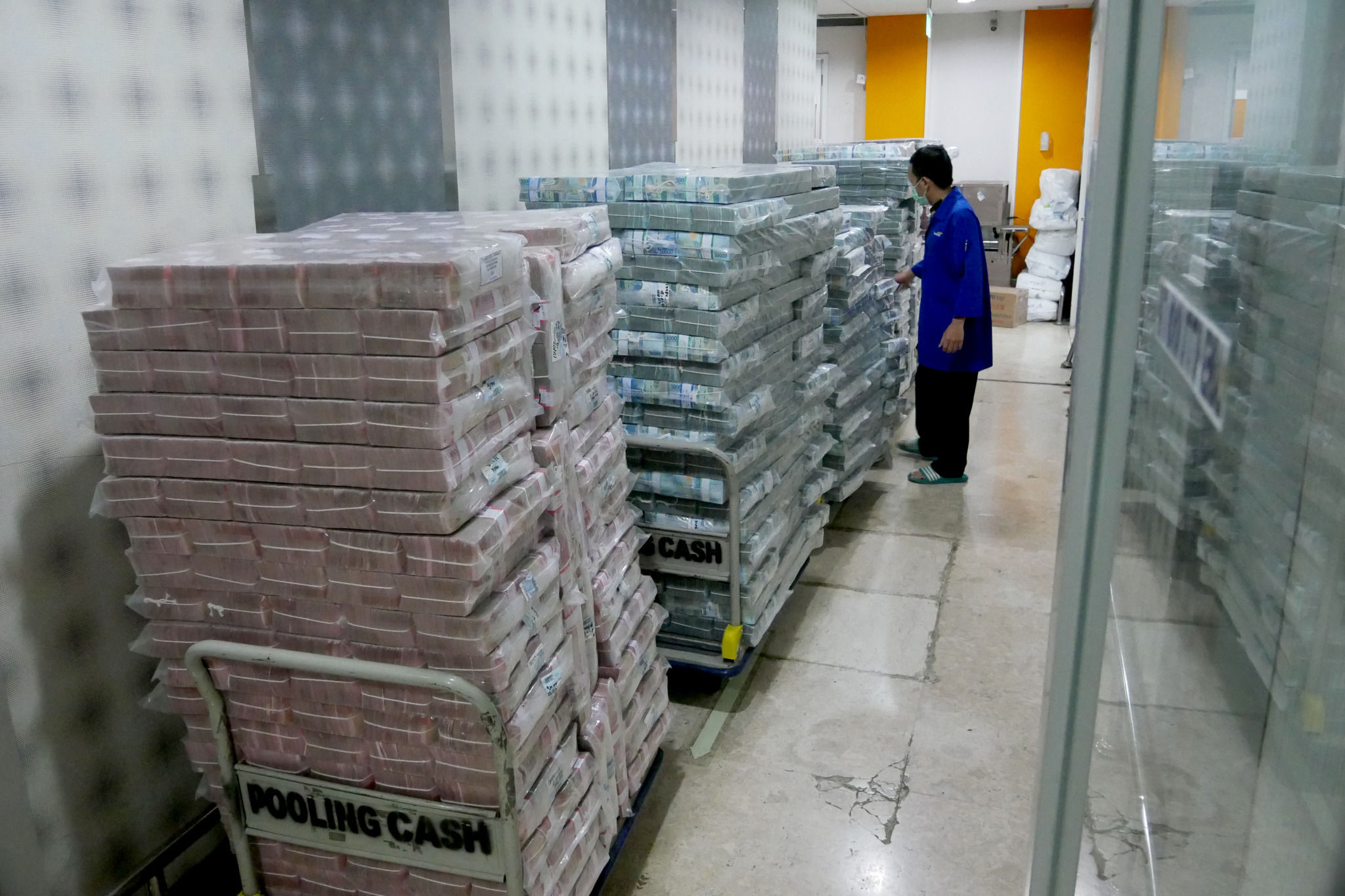 Karyawan memindahkan tumpukan uang rupiah di cash pooling Bank Mandiri, Jakarta, Jum'at, 21 Januari 2022. Foto: Ismail Pohan/TrenAsia