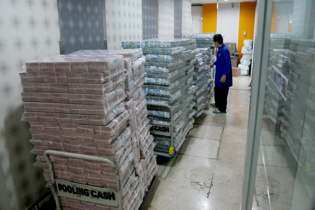 Karyawan memindahkan tumpukan uang rupiah di cash pooling Bank Mandiri, Jakarta, Jum'at, 21 Januari 2022. Foto: Ismail Pohan/TrenAsia