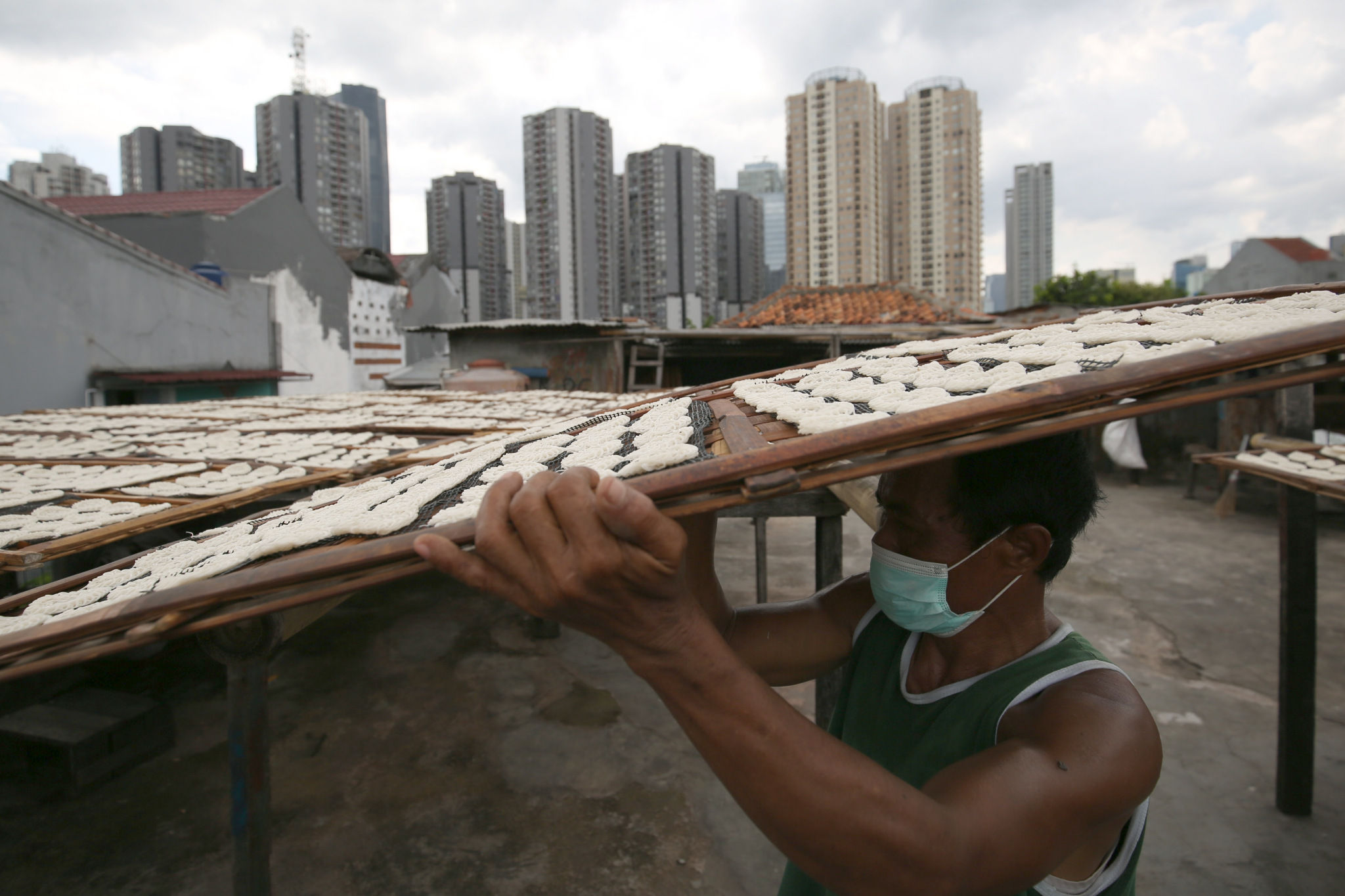 Pekerja menjemur kerupuk di industri rumahan pembuatan kerupuk di kawasan Manggarai, Jakarta Selatan, Senin, 24 Januari 2022. Foto: Ismail Pohan/TrenAsia
