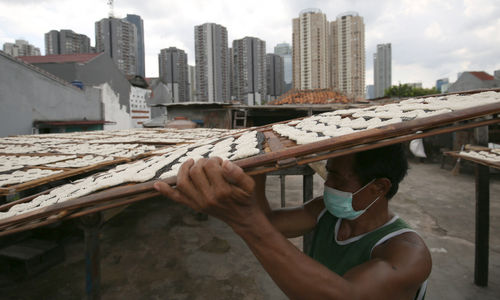 Pekerja menjemur kerupuk di industri rumahan pembuatan kerupuk di kawasan Manggarai, Jakarta Selatan, Senin, 24 Januari 2022. Foto: Ismail Pohan/TrenAsia