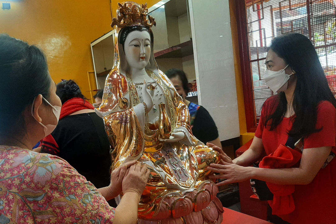 Warga keturunan Tionghoa menghias patung dewa pada kegiatan bersih- bersih menjelang peringatan Tahun Baru Imlek di Vihara Amurva Bhumi, Jakarta Selatan, Selasa, 25 Januari 2022. Foto: Ismail Pohan/TrenAsia