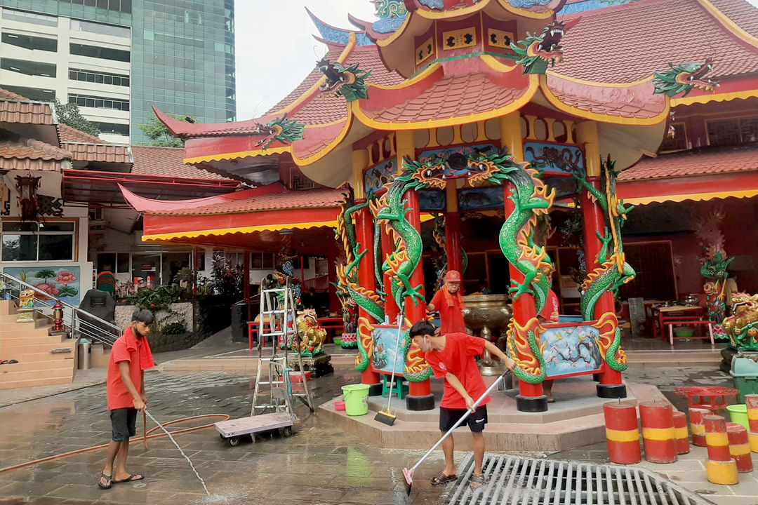 Pekerja membersihkan halaman Vihara Amurva Bhumi, di Jakarta Selatan, Selasa, 25 Januari 2022. Foto: Ismail Pohan/TrenAsia