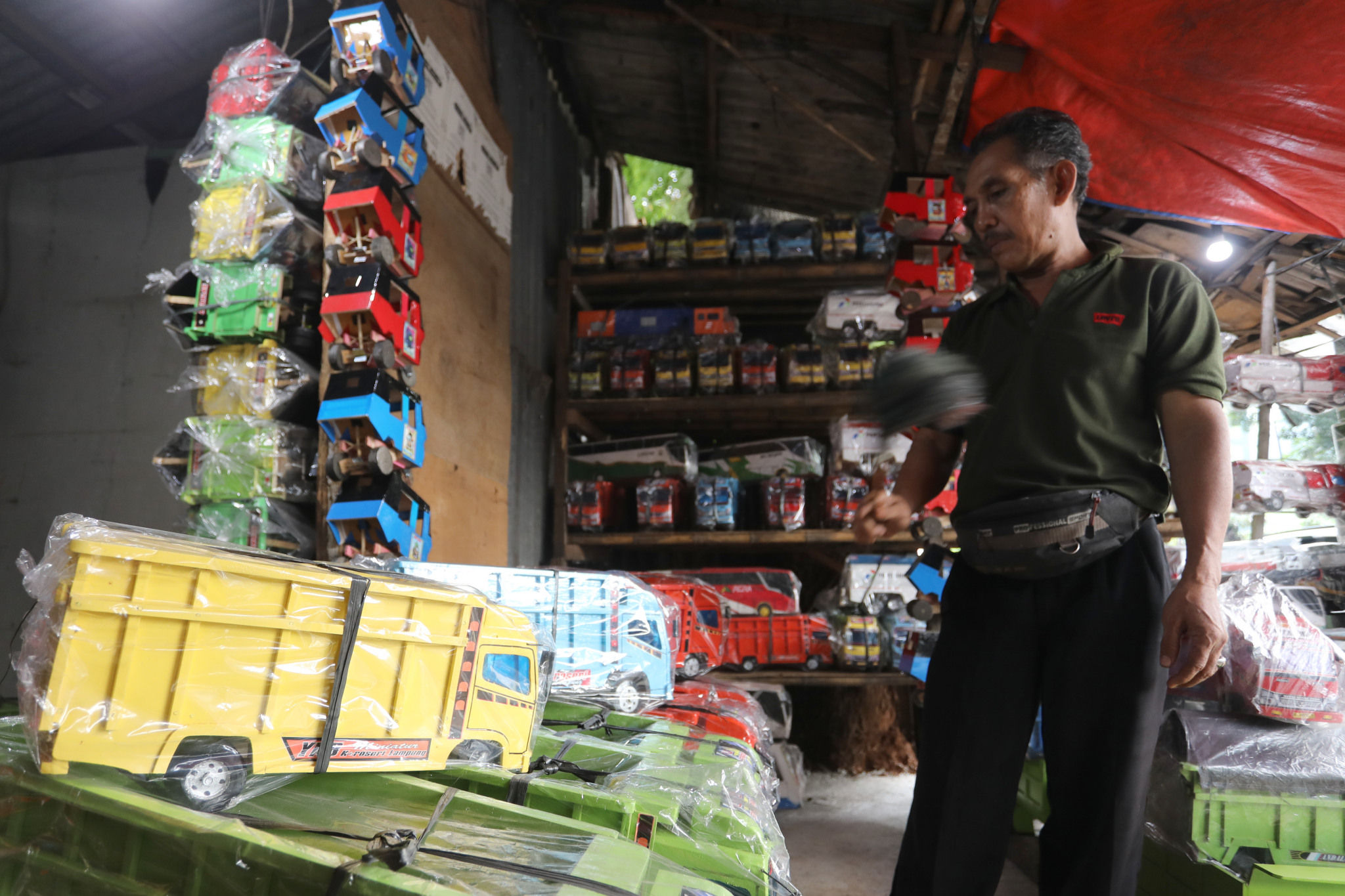 Pedagang beraktivitas di kiosnya yang menjual miniatur kendaraan berbahan kayu kawasan Kalibata, Jakarta, Jum'at, 28 Januari 2022. Foto: Ismail Pohan/TrenAsia
