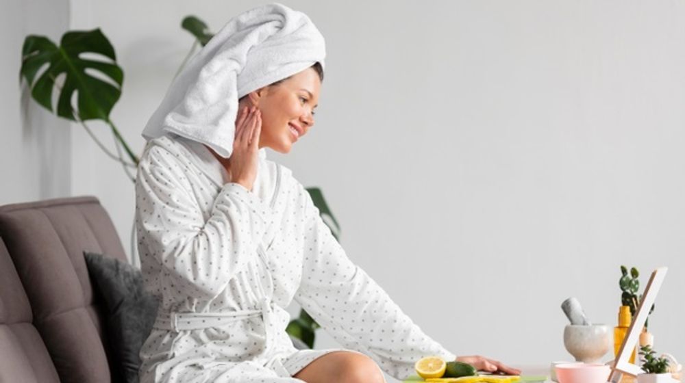 side-view-woman-bathrobe-using-skincare_23-2148655808.jpg