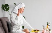 side-view-woman-bathrobe-using-skincare_23-2148655808.jpg