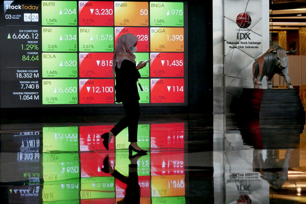 Karyawan beraktifitas dengan latar layar pergerakan indeks harga saham gabungan (IHSG) pada perdagangan perdana di gedung Bursa Efek Indonesia (BEI), Jakarta, Senin, 3 Januari 2022