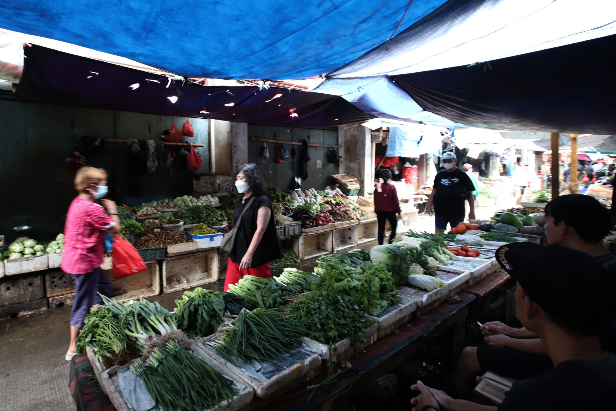 Warga melintas diantara lapak pedagang yang menjual bahan pokok di salah satu pasar tradisional di Jakarta, Selasa, 8 Februari 2022. Foto: Ismail Pohan/TrenAsia