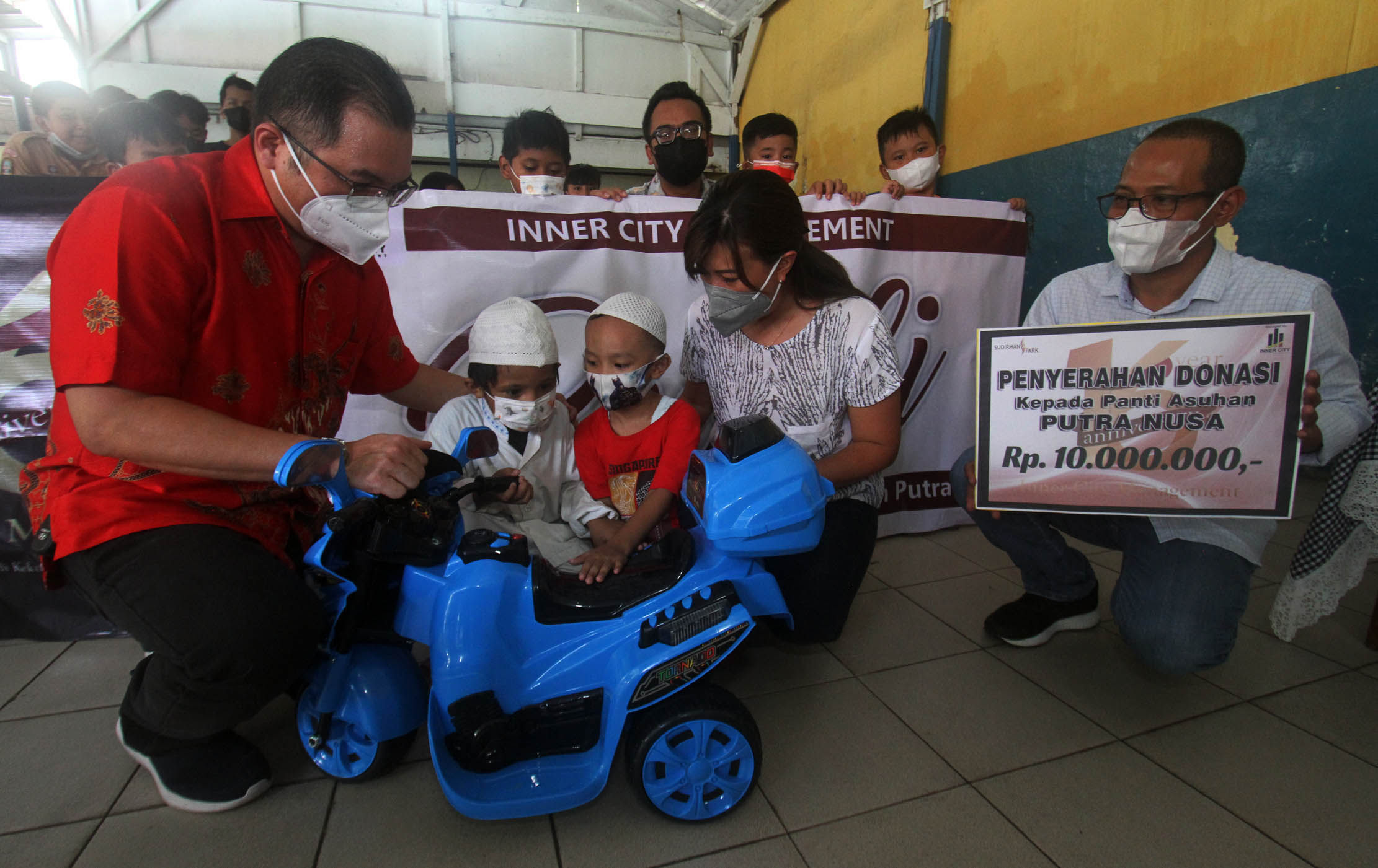 Ketua Panitia HUT ke-16 Inner City Management (ICM) Anggie Febrianti - Ketua PPRS Apartemen Sudirman Park Rusli Usman - Pimpinan Yayasan Putra Nusa Jakarta Pusat Asep Saefudin berfoto bersama anak-anak dari panti asuhan di Jakarta, Rabu 2 Maret 2022. Foto : Panji Asmoro/TrenAsia