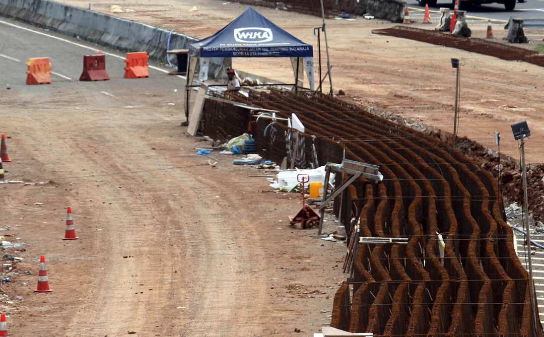 Nampak sejumlah pekerja menggunakan alat berat menyelesaikan pembangunan jalan tol Serpong - Balaraja (Serbaraja) di kawasan Rawa Buntu , Tangerang Selatan Selasa 8 Maret 2022. Foto : Panji Asmoro/TrenAsia