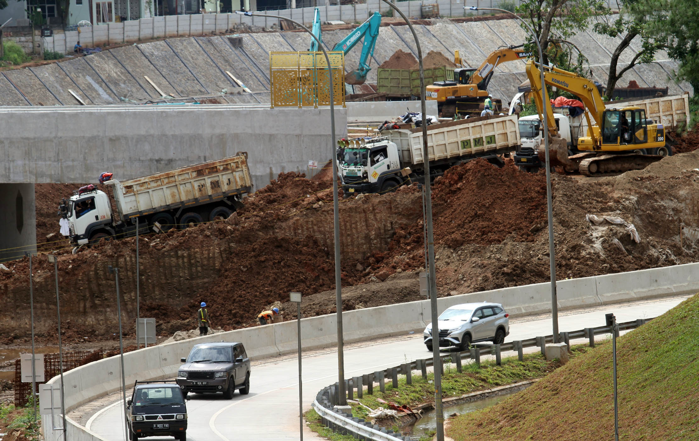 Nampak sejumlah pekerja menggunakan alat berat menyelesaikan pembangunan jalan tol Serpong - Balaraja (Serbaraja) di kawasan Rawa Buntu , Tangerang Selatan Selasa 8 Maret 2022. Foto : Panji Asmoro/TrenAsia