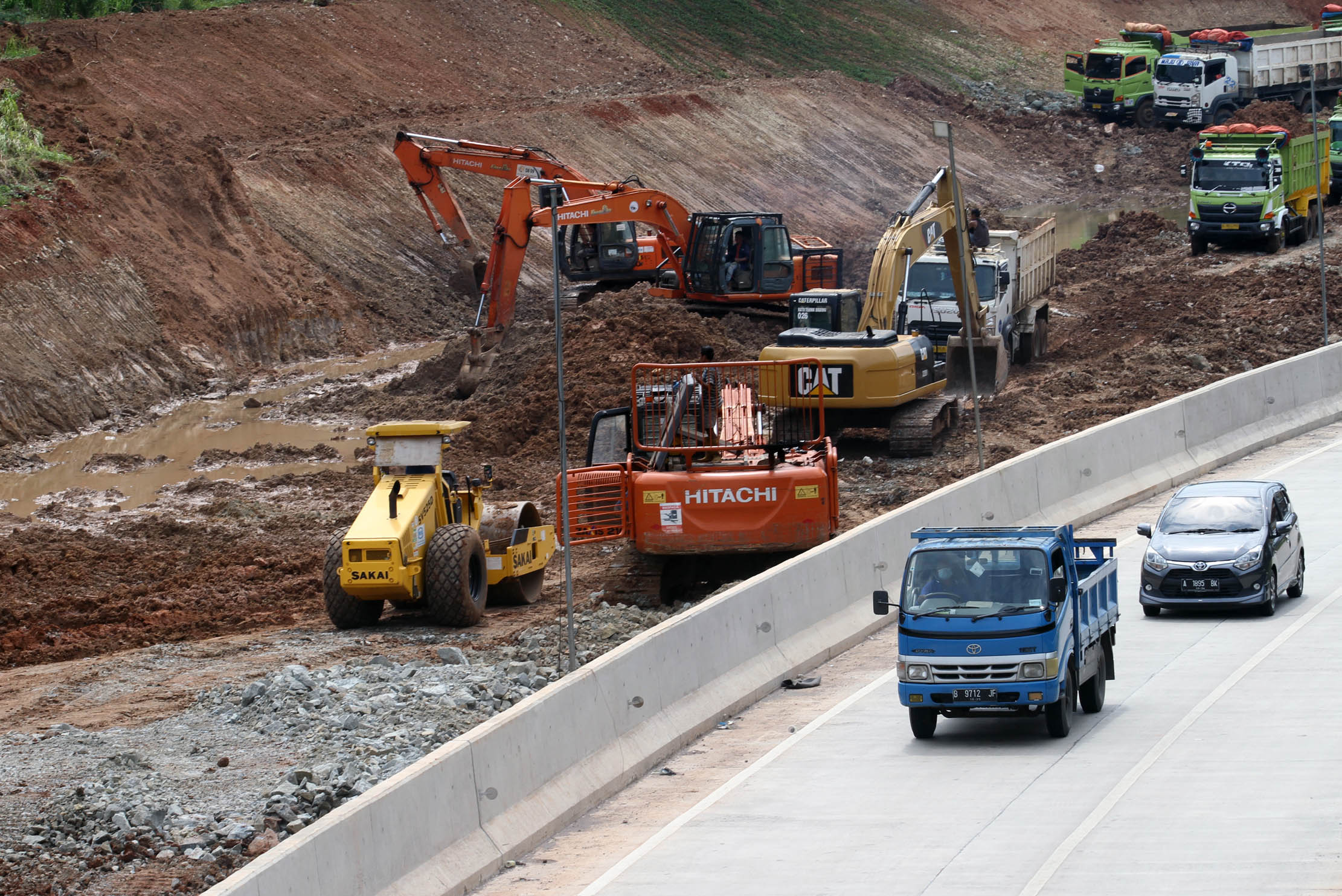 Nampak sejumlah pekerja menggunakan alat berat menyelesaikan pembangunan jalan tol Serpong - Balaraja (Serbaraja) di kawasan Rawa Buntu , Tangerang Selatan Selasa 8 Maret 2022. Foto : Panji Asmoro/TrenAsia