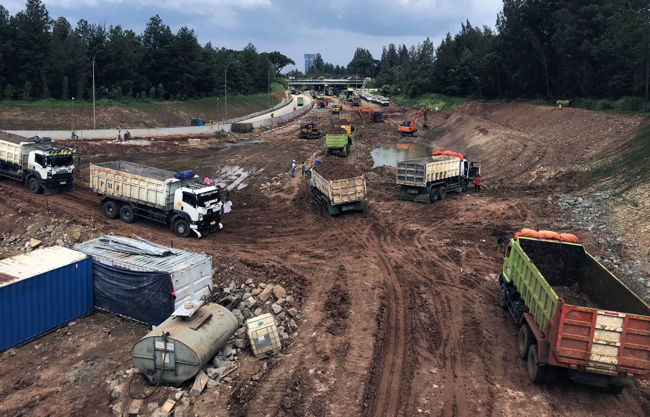Nampak sejumlah pekerja menggunakan alat berat menyelesaikan pembangunan jalan tol Serpong - Balaraja (Serbaraja) di kawasan Rawa Buntu , Tangerang Selatan Selasa 8 Maret 2022. Foto : Panji Asmoro/TrenAsia