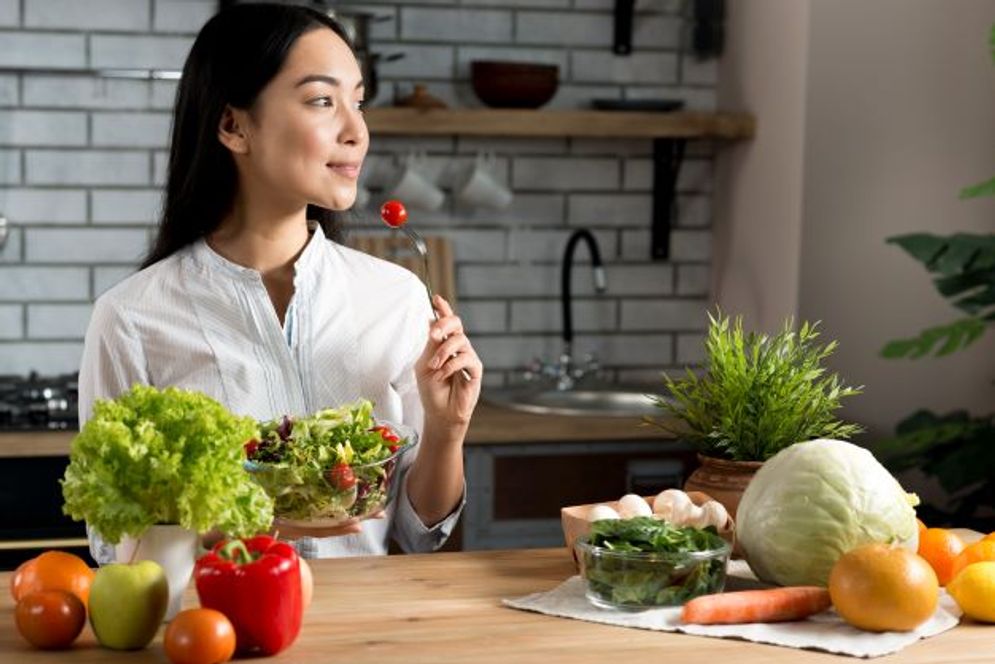 pretty-young-woman-eating-red-cherry-tomato-holding-bowl-mixed-salad.jpg