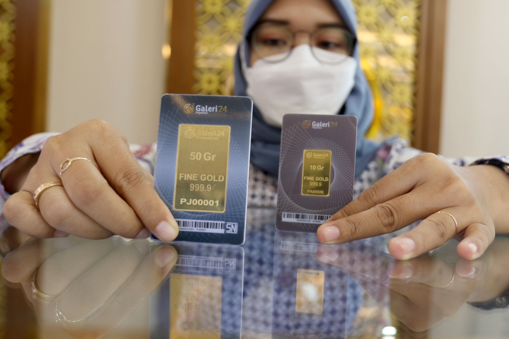 Karyawan menunjukkan emas batangan di Galeri 24 Pegadaian, Jakarta, Rabu, 23 Maret 2022. Foto: Ismail Pohan/TrenAsia