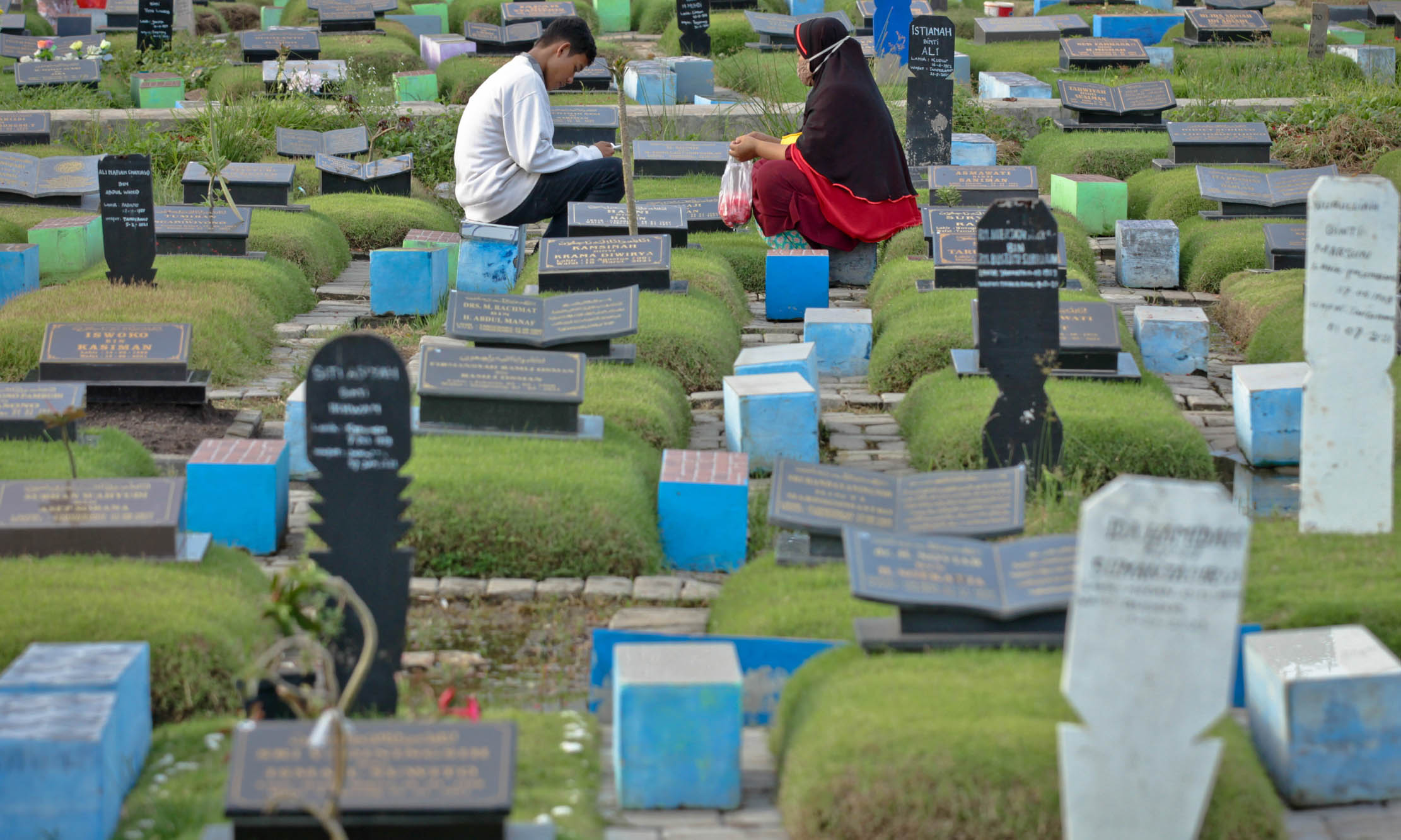 Nampak sejumlah warga peziarah berdoa di makam keluarga dan kerabatnya saat ziarah kubur menjelang bulan ramadhan di TPU Selapajang, Kota Tangerang, Senin 28 Maret 2022.  Foto : Panji Asmoro/TrenAsia