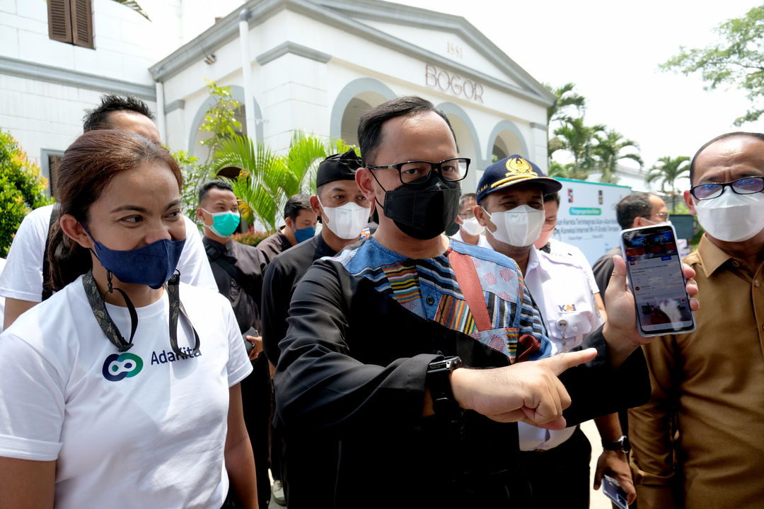 Wali Kota Bogor Bima Arya (tengah) didampingi Direktur Pengembangan Bisnis PT Solusi Sinergi Digital Tbk. (Surge) Martha Rebecca (kiri) saat mencoba koneksi WiFi gratis tercepat dengan kapasitas 2000 Mbps, usai pemecahan Museum Rekor Dunia Indonesia (MURI) di area Stasiun Bogor, Jawa Barat, Kamis, 31 Maret 2021. Foto: Ismail Pohan/TrenAsia