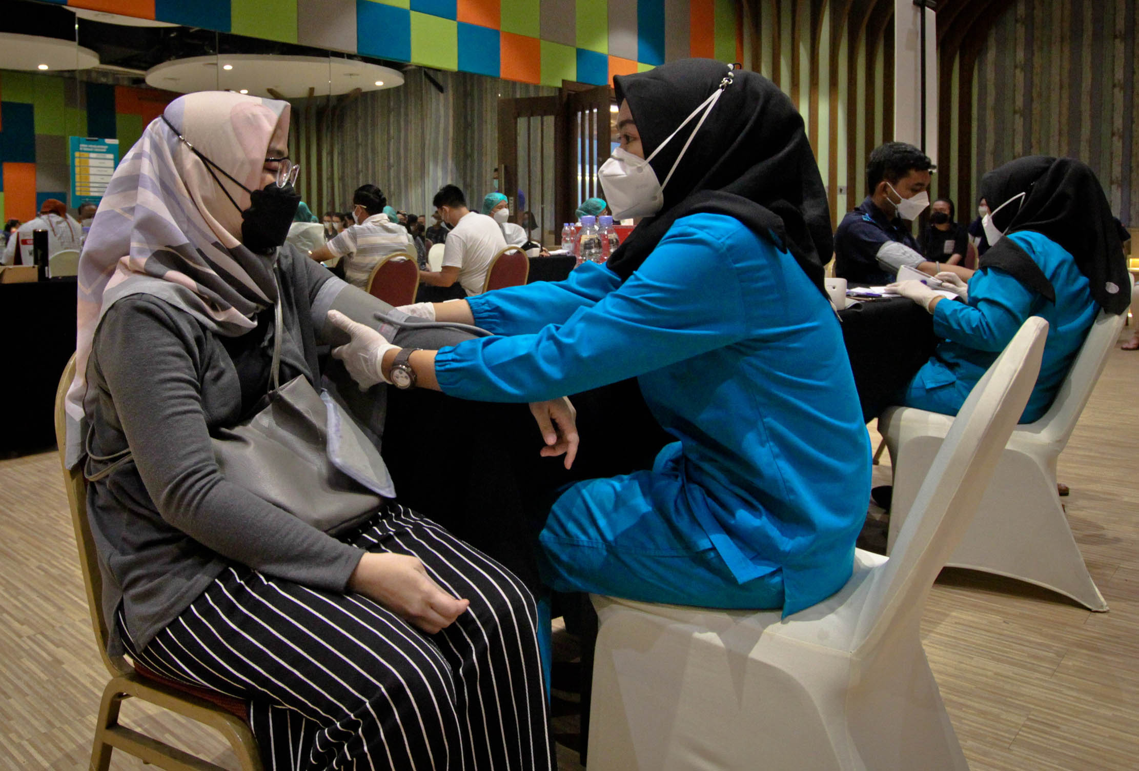 Nampak para peserta tengah mengikuti pelaksanaan Vaksinasi Booster yang digelar menjelang HUT ke-40 BFI Finance yang berlangsung di QBig Tangerang,Kamis 31 Maret 2022. Foto : Panji Asmoro/TrenAsia