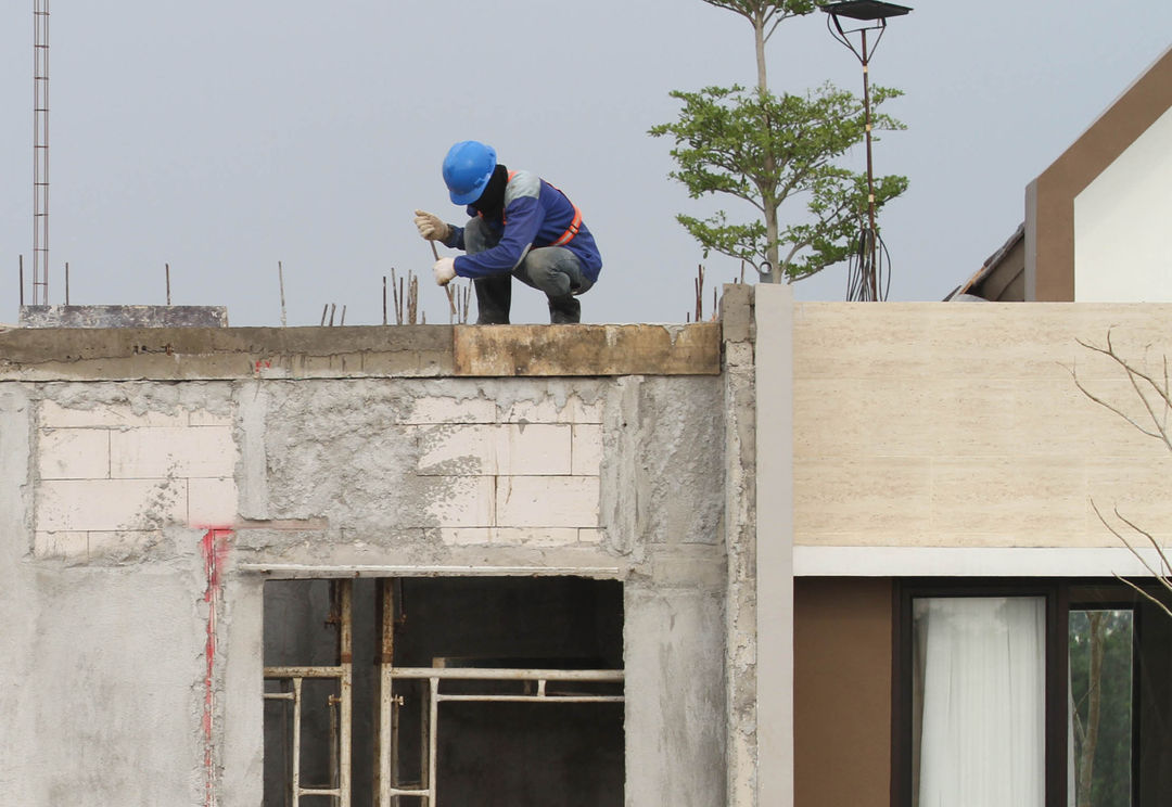 Nampak sejumlah pekerja proyek tengah mengerjakan pambangunan di perumahan Podomoro Tenjo, Jumat 1 April 2022. Foto : Panji Asmoro/TrenAsia