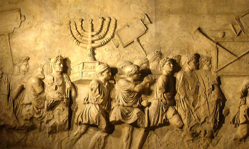 Ukiran di Arch of Titus yang menggambarkan pasukan Romawi yang membawa menorah dari kuil suci Yahudi, The Second Temple.