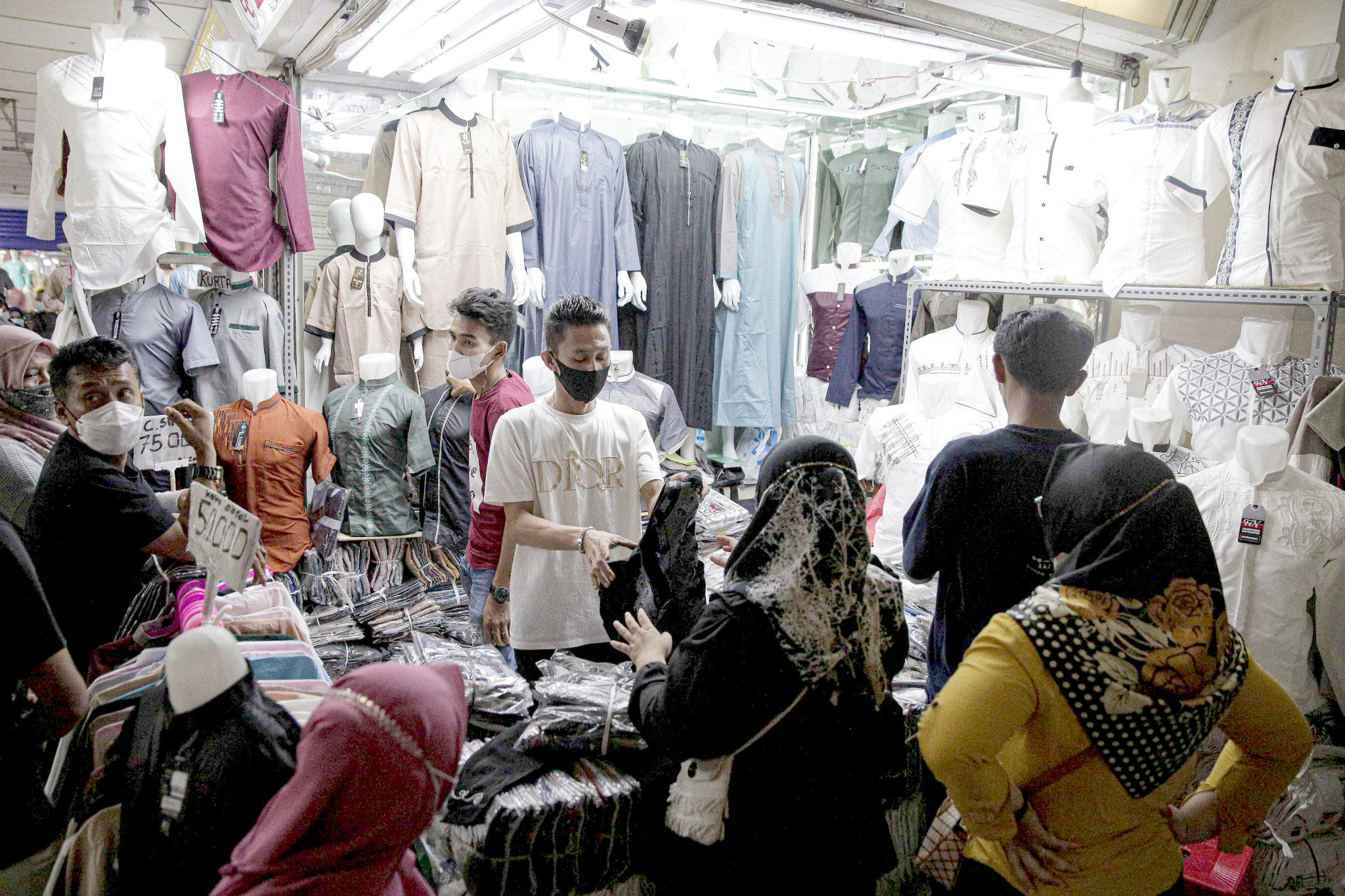 Warga memilih busana muslim di salah satu kios pedagang pasar Tanah Abang, Jakarta, Senin, 11 April 2022. Foto: Ismail Pohan/TrenAsia