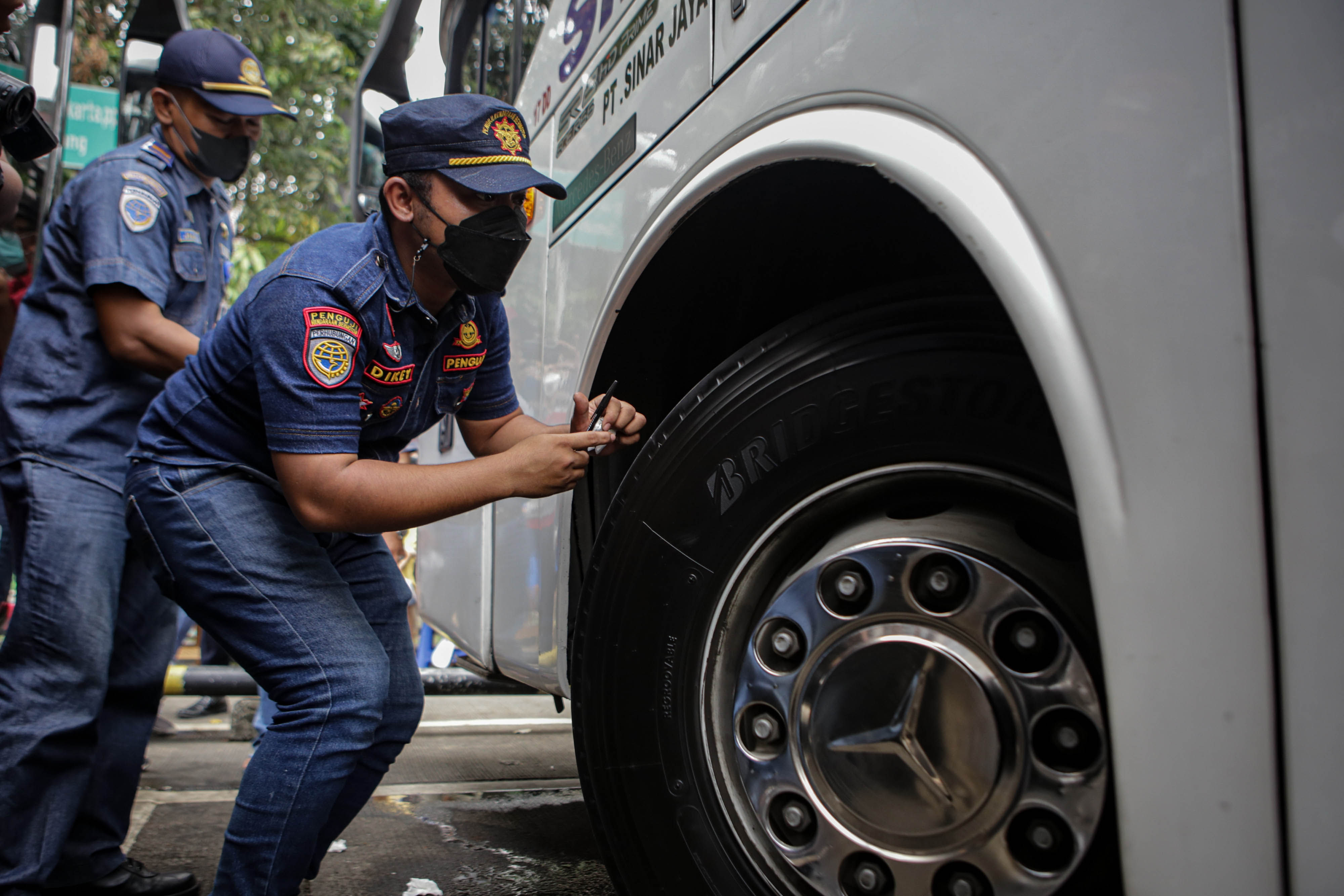 Petugas melihat kondisi angkutan bus saat pemeriksaan kelayakan kendaraan (ramp check) jelang mudik Lebaran di Terminal Poris Plawad, Kota Tangerang, Banten, Senin 18 April 2022. Foto : Panji Asmoro/TrenAsia