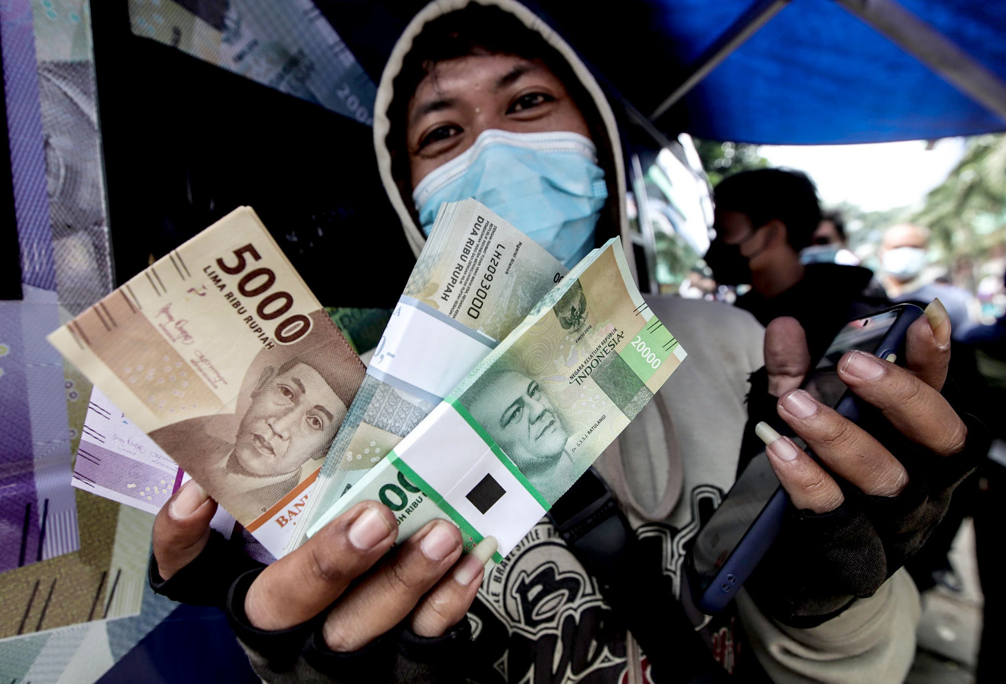 Warga melakukan penukaran uang baru untuk lebaran di mobil kas keliling Bank Indonesia (BI) Pasar Palmerah, Jakarta Barat, Rabu, 20 April 2022. Foto: Ismail Pohan/TrenAsia