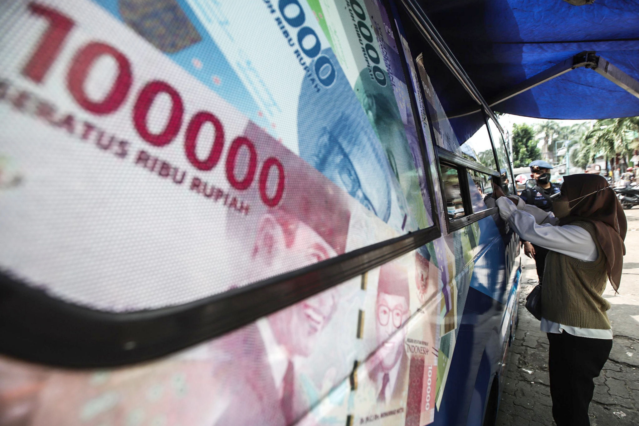 Warga melakukan penukaran uang baru untuk lebaran di mobil kas keliling Bank Indonesia (BI) Pasar Palmerah, Jakarta Barat, Rabu, 20 April 2022. Foto: Ismail Pohan/TrenAsia