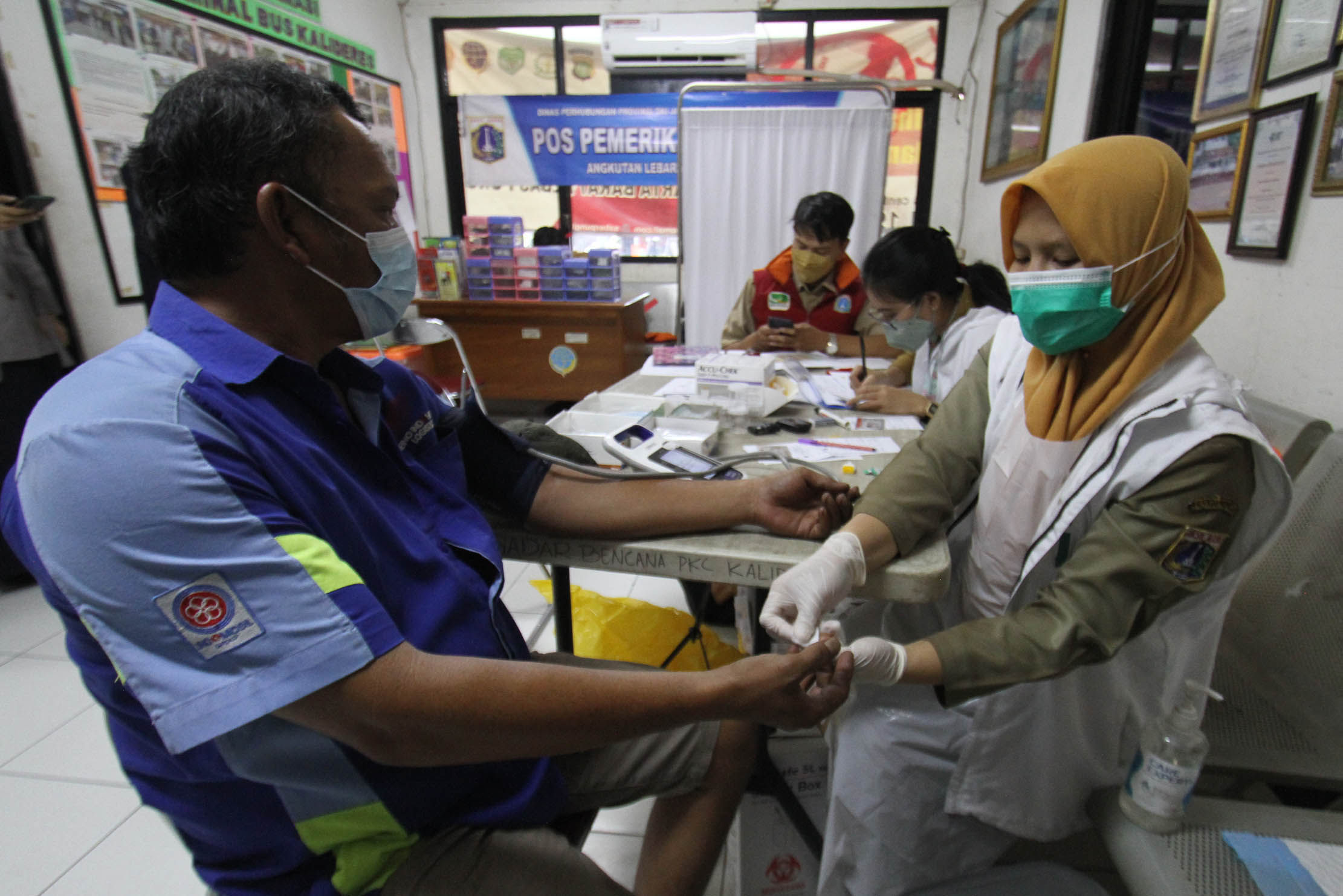 Sejumlah pengemudi bus antar kota menjalani pemeriksaan kesehatan di Terminal Kalideres Jakarta Barat. Pemeriksaan tersebut meliputi tensi,urine dan gula darah, Senin 25 April 2022. Foto : Panji Asmoro/TrenAsia