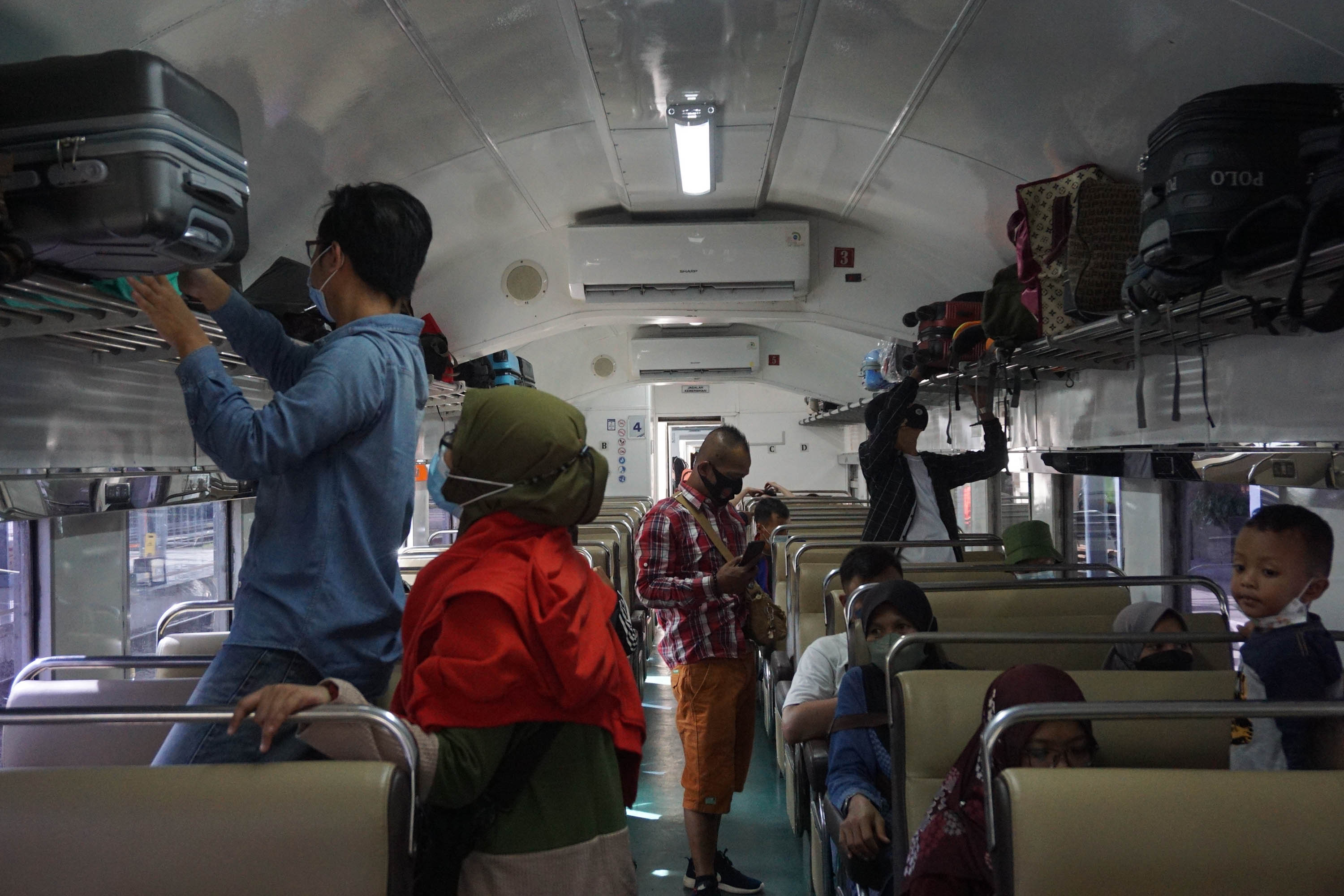 Pemudik menata barang di bagasi gerbong kereta api Gumarang relasi Jakarta Pasar Senen- Surabaya Pasar Turi di Stasiun Pasar Senen, Jakarta, Jum'at, 29 April 2022. Foto: Ismail Pohan/TrenAsia