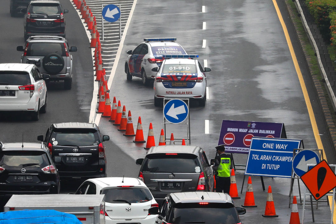 Petugas mengarahkan kendaraan saat penutupan Jalan Tol Dalam Kota yang mengarah ke Tol Cikampek di Jakarta, Sabtu, 7 Mei 2022. Foto: Ismail Pohan/TrenAsia