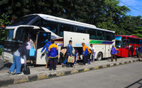 Pemudik membawa barang bawaannya setelah turun dari bus antarkota pada arus balik lebaran di Terminal Kampung Rambutan, Jakarta Timur, Minggu, 8 Mei 2022. Foto: Ismail Pohan/TrenAsia