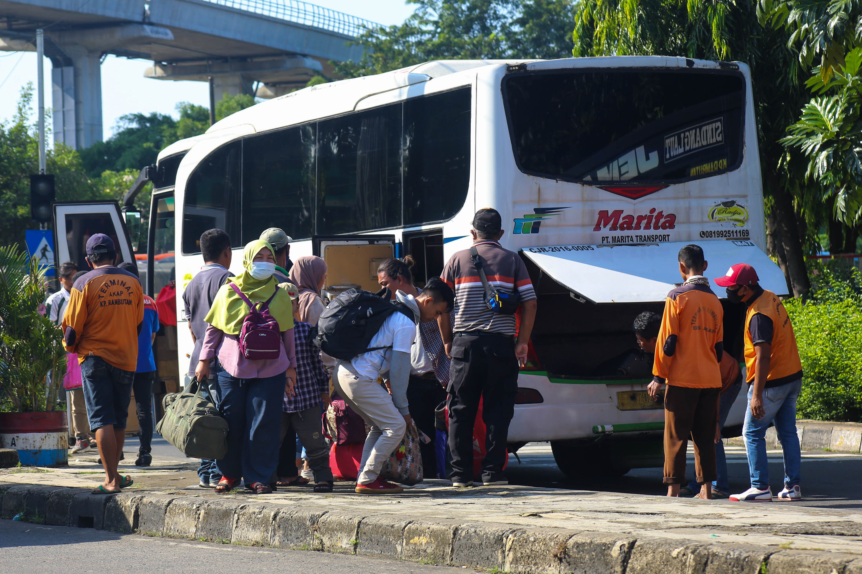 Pemudik mengambil barang bawaannya setelah turun dari bus antarkota pada arus balik lebaran di Terminal Kampung Rambutan, Jakarta Timur, Minggu, 8 Mei 2022. Foto: Ismail Pohan/TrenAsia