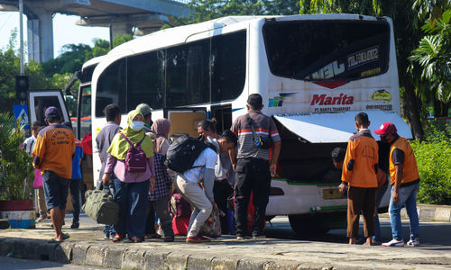 Pemudik mengambil barang bawaannya setelah turun dari bus antarkota pada arus balik lebaran di Terminal Kampung Rambutan, Jakarta Timur, Minggu, 8 Mei 2022. Foto: Ismail Pohan/TrenAsia