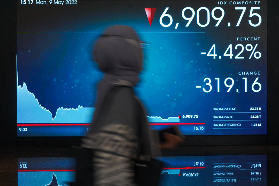 Karyawan melintas di depan layar pergerakan indeks harga saham gabungan (IHSG) di gedung Bursa Efek Indonesia (BEI) Jakarta, Senin, 9 Mei 2022. Foto: Ismail Pohan/TrenAsia